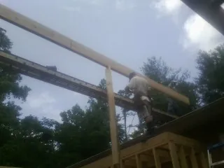 Carpenter setting a ridge beam over a new addition frame — Ice Dam Removal by Roofing Brothers in Baldwin Place