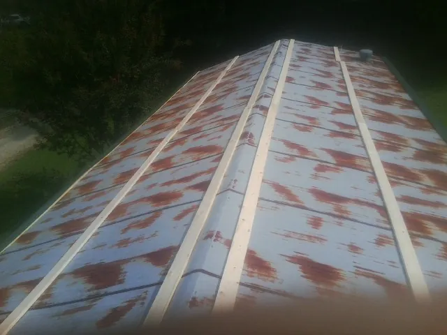 Rusted metal roof panels with new wood purlins before replacement — Storm Damage Roof Repair in Baldwin Place by Roofing Brothers