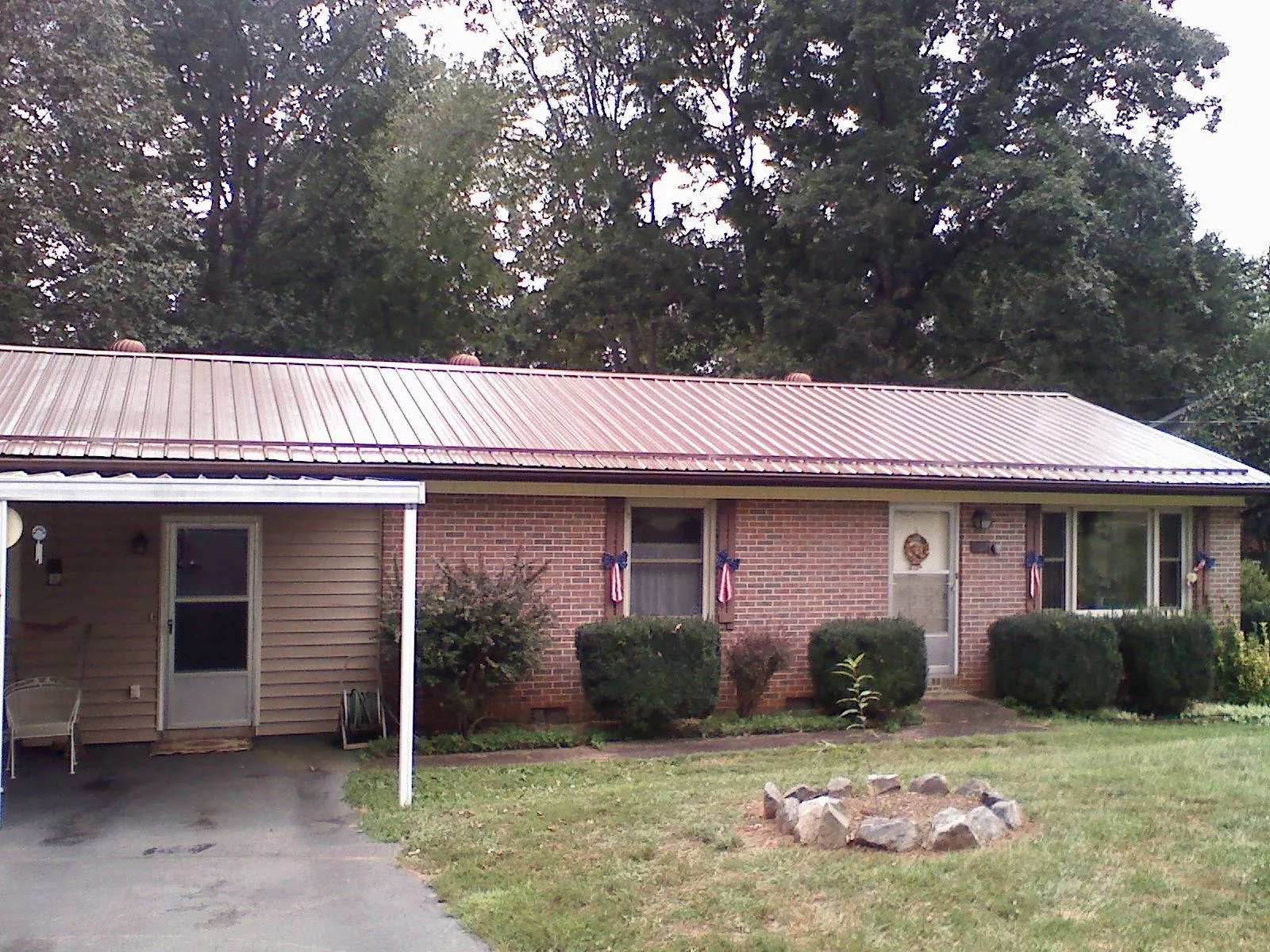 Bronze metal roof and carport on a brick ranch home — Roof Repair work by our crew in Baldwin Place
